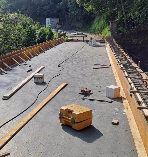 Foto con particolare dei lavori: in primo piano la gettata del tratto di strada sul ponte, sul lato destro e sinistro le armature dei cordoli pronte per essere gettate