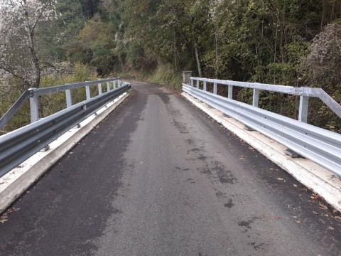 Nella foto in primo piano il tratto di strada sul ponte con il nuovo asfalto e ai lati i nuovi cordoli e le nuve barriere