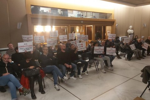 Nella foto i gruppo di grossisti operanti sul territorio seduti in sala con cartelli protesta