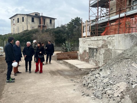 Nella foto il presidente e gli altri partecipanti di fornte al cantiere dell'albergheiro Minuto