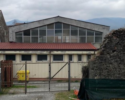 Nella foto in primo piano il cancello di ingresso della palestra e sullo sfondo la struttura interessata