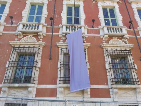 Nella foto una delle finestre del piano noble del Palazzo duale di Massa con un drappo viola che sc2ende fino al piano terra