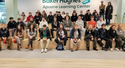 Foto di gruppo degli studenti in un ambiente interno con scritta sullo sfondo 