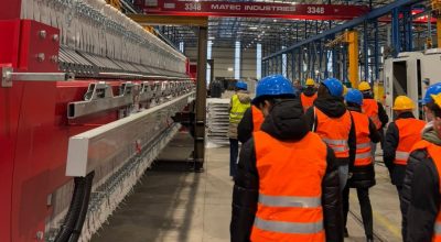 Nella foto gruppo di studenti di spalle in visita nel capannone