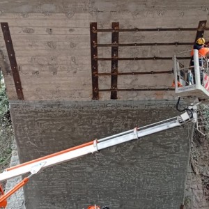 Nella foto piattaforma elevatrice con operaio al lavoro sotto il ponte