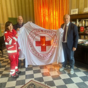 Nella foto due volontari della CRI consegano la bandiera al presidente Lorenzetti
