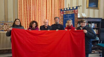 Nella foto, interno ufficio prsidenza di fronte al Gonfalone gruppo dei partecipanti tengono e mostrano il drappo rosso
