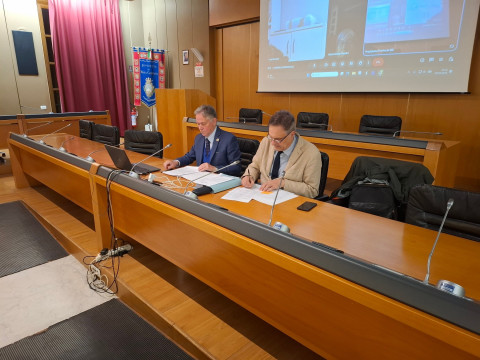 Foto con il tavlo della presidenza e seduti il presidente e il segretario generale